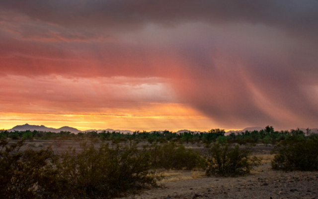 A summer monsoon dumps rain in the distance during a colorful sunset near Blythe, California
